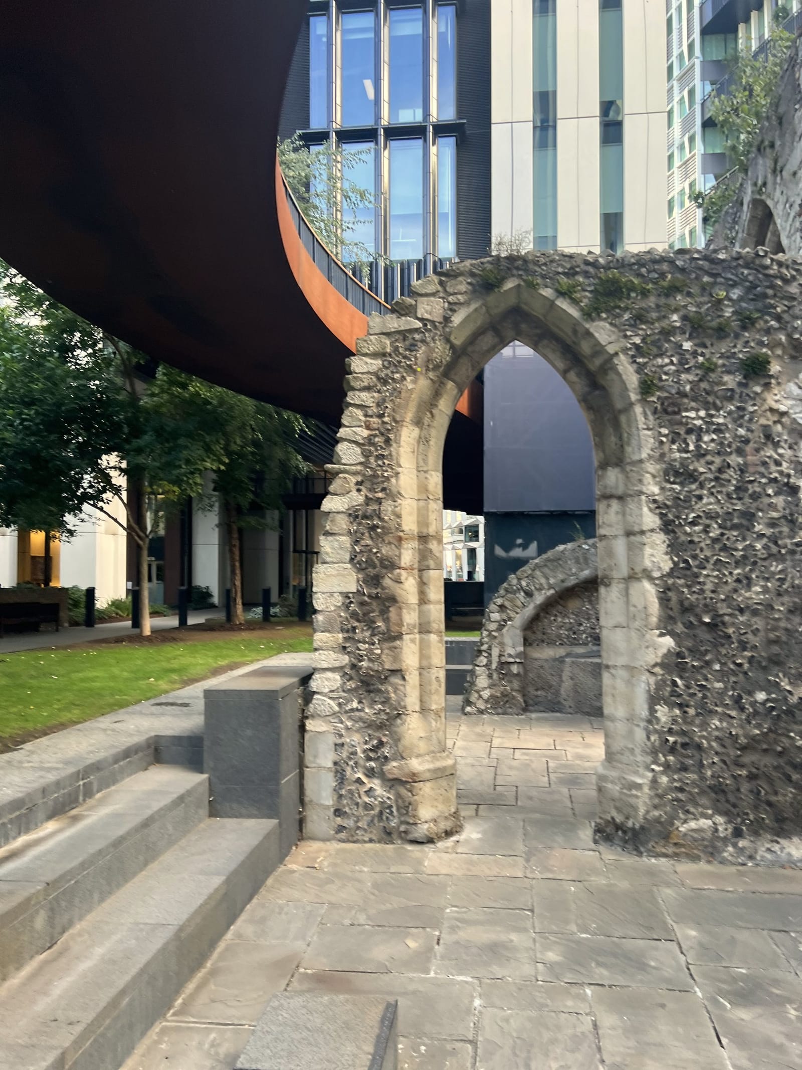 The medieval stone arch of St Alphage on London Wall, framed by modern City buildings